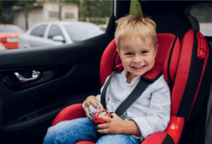 blond young boy sitting in a car seat
